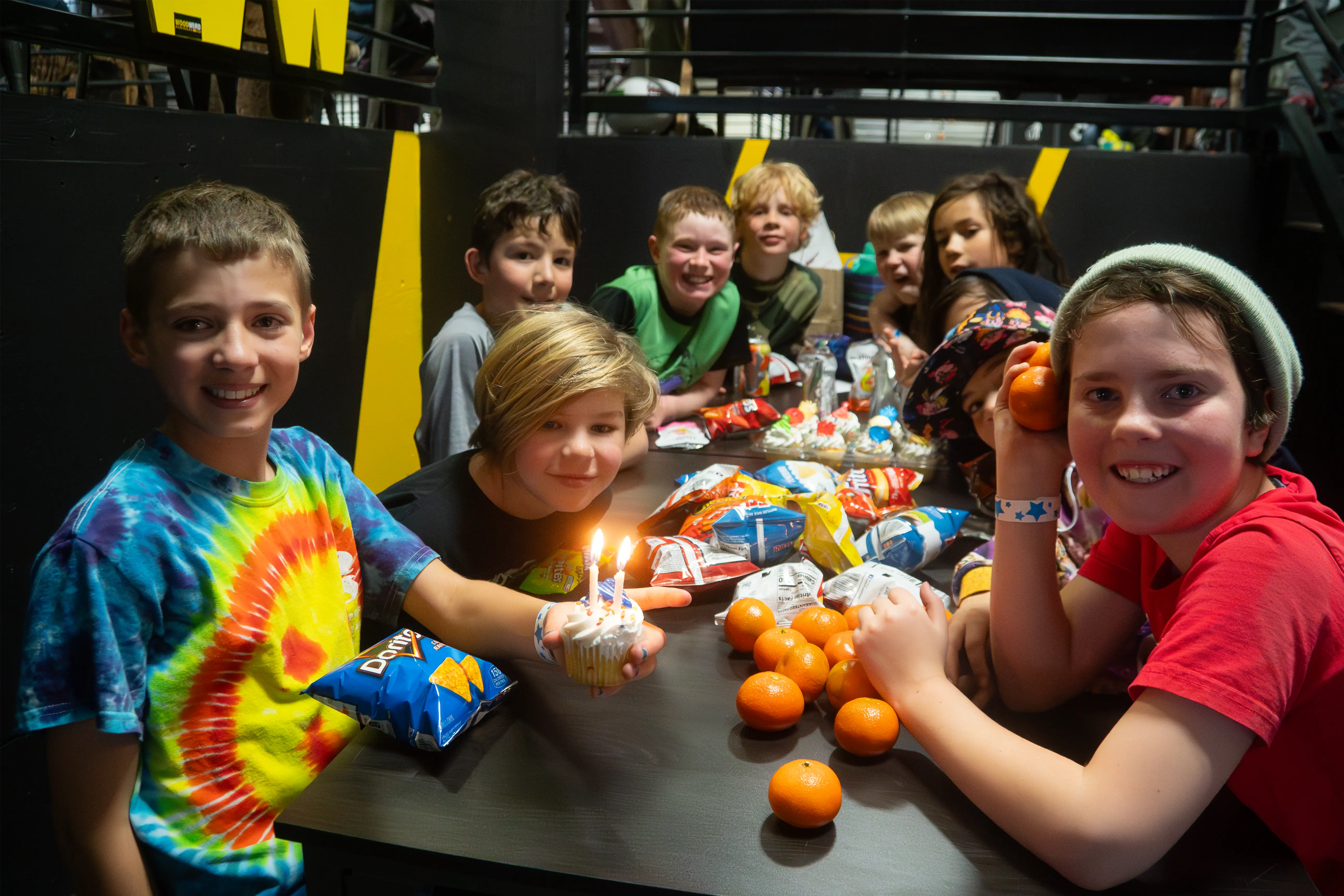 Kids at table with cupcakes and food smiling