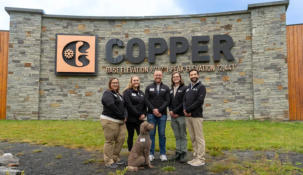 rental owner services team standing at the Copper entrance sign