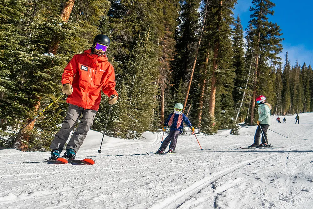 instructor and two students skiing in West Village